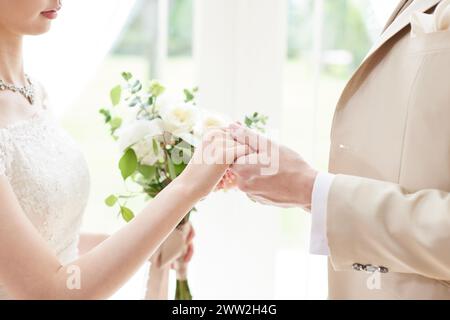 Ein Mann und eine Frau, die Hände halten und Ringe austauschen Stockfoto