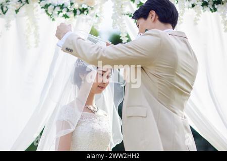 Der Bräutigam hebt den Brautschleier auf der Hochzeit Stockfoto