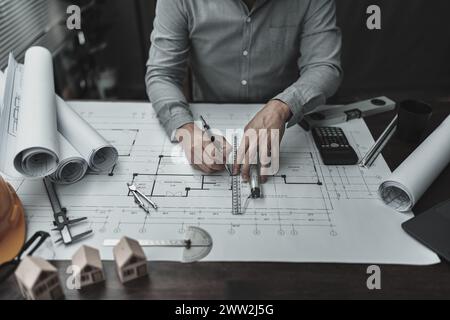 Architekt Ingenieur verwendet Stift- und Mini-T-Slide-Zeichendesign und arbeitet an Blueprint. Hausplanung und Baukonzept. Stockfoto