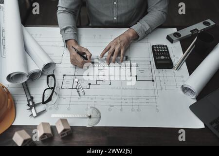 Architekt Ingenieur verwendet Stift- und Mini-T-Slide-Zeichendesign und arbeitet an Blueprint. Hausplanung und Baukonzept. Stockfoto