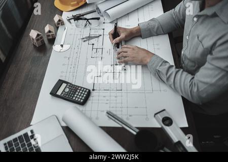 Architekt Ingenieur verwendet Stift- und Mini-T-Slide-Zeichendesign und arbeitet an Blueprint. Hausplanung und Baukonzept. Stockfoto