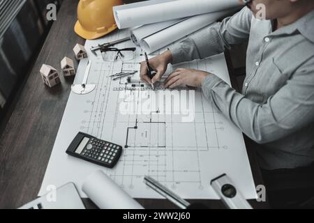 Architekt Ingenieur verwendet Stift- und Mini-T-Slide-Zeichendesign und arbeitet an Blueprint. Hausplanung und Baukonzept. Stockfoto