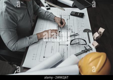 Architekt Ingenieur verwendet Stift- und Mini-T-Slide-Zeichendesign und arbeitet an Blueprint. Hausplanung und Baukonzept. Stockfoto