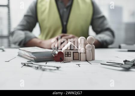 Hausmodell, Holzpuppe, Schlüssel und Geld auf dem Hauslayout repersent Familie spart Geld Haus und Sicherheit kaufen. Architekt- und Ingenieurkonzept. Stockfoto