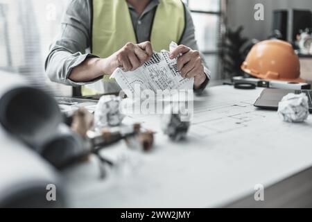 Der Architekt machte einen Fehler beim Entwurf des Plans und zerrissenes Papier. Papiercrump auf Blueprint. Fehler, Fehler und Problem Konzept. Stockfoto
