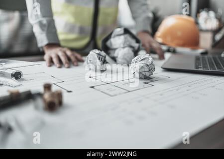Der Architekt machte einen Fehler beim Entwurf des Plans. Papiercrump auf Blueprint. Fehler, Fehler und Problem Konzept. Stockfoto