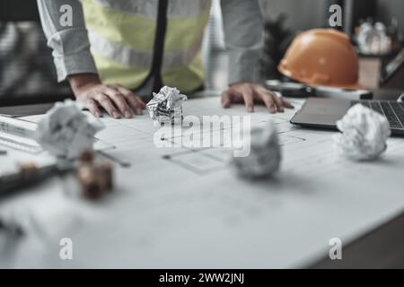 Der Architekt machte einen Fehler beim Entwurf des Plans. Papiercrump auf Blueprint. Fehler, Fehler und Problem Konzept. Stockfoto