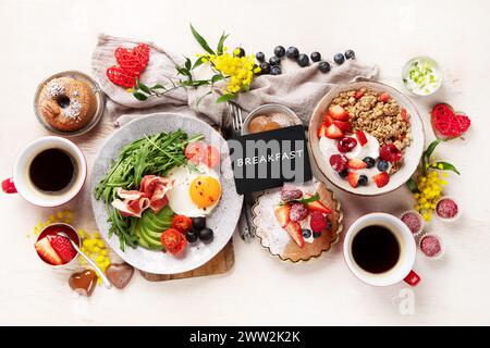 Gesundes Frühstück mit Haferflocken, Beeren, Ei, Speck und einer Tasse Kaffee. Guten Morgen. Draufsicht Stockfoto