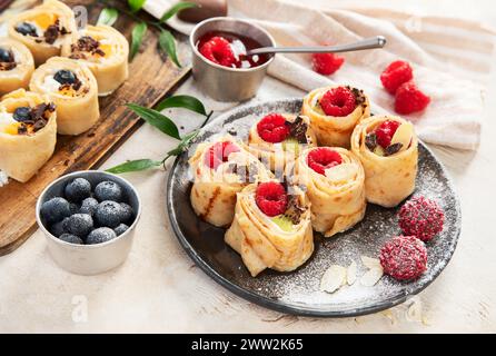 Asiatischer süßer Sushi-Pfannkuchen. Brötchen mit Frischkäse, Beeren und Früchten Stockfoto