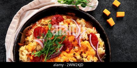 Trendiges Hybrid-Essen. Mac und Käse Pizza auf dunklem Hintergrund. Draufsicht Stockfoto