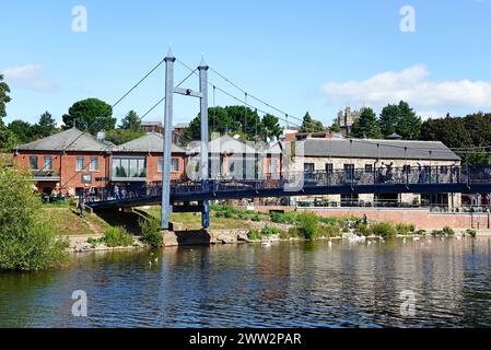 Blick auf die Cricklepit Hängebrücke über den Fluss exe mit Schwänen im Vordergrund und Restaurant am Ufer im hinteren Teil, Exeter, Devon, Großbritannien. Stockfoto