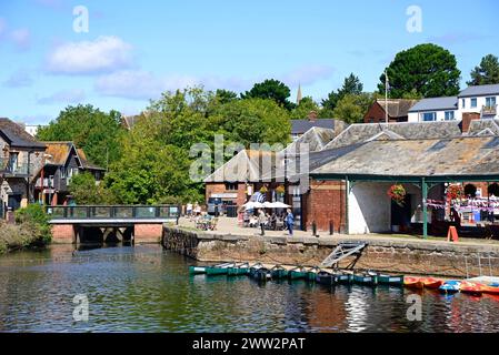 Blick über den Fluss exe in Richtung einer kleinen Fußgängerbrücke und Restaurants entlang des East Quay, Exeter, Devon, Großbritannien, Europa. Stockfoto