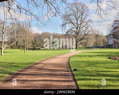 An einem sonnigen Wintertag durchqueren Sie die Gärten des Holyrood Palace (holyroodhouse) in Edinburgh, der Heimat des britischen Monarchen in Schottland. Stockfoto