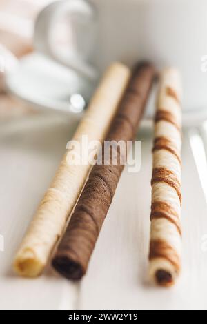 Verschiedene Schokoladen- und Vanillescremes-gefüllte Waffelrollen auf einem weißen Tisch. Stockfoto