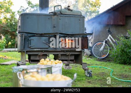 Holzofen. Die Tür des Herds im Freien wird als Feldküche verwendet. Alter alter alter Brennholzofen. Stockfoto