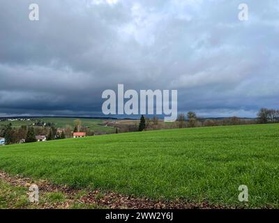 Dunkle Sturmwolken sammeln sich über einem Dorf Stockfoto