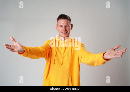 Porträt eines verwirrten ahnungslosen Mannes auf grauem Hintergrund im Atelier Stockfoto