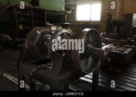 Oldtimer-Maschinen in der alten Fabrik, Industriegetriebe auf der Werkbank. Historische Produktionsanlagen, Werkstattwerkzeuge. Stockfoto