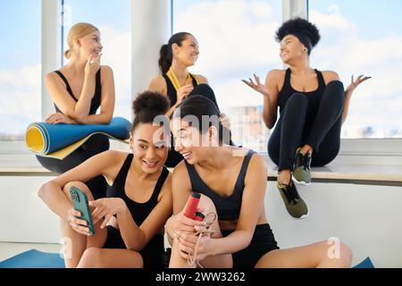 Gruppe von fröhlichen fünf weiblichen Freunden in Sportbekleidung, die nach dem Training im Pilates Studio plaudern Stockfoto