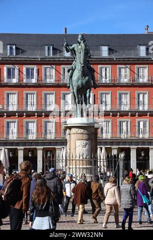 Madrid, Spanien. La Plaza Major. Rechteckige Esplanade wurde 1620 eröffnet. Statue von König Philipp 111 von Jean Boulogne. Geschäftiger gewölbter und säulenförmiger Platz. Stockfoto