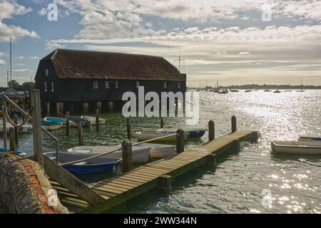 Bosham Quay in Chichester Harbour, West Sussex, England. Mit verankerten Booten und Anlegestelle. Stockfoto