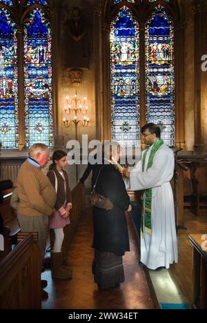 Katholiken, jung und alt, stehen sich an, um vom römisch-katholischen Priester gesegnet zu werden, in einem jährlichen katholischen Ritual der Zeremonie des Throats, 3. Februar Kerzen werden an beiden Seiten der Kehle platziert. Die katholische Kirche St. Etheldreda. Ely Place London. HOMER SYKES AUS DEN 2000ER JAHREN Stockfoto