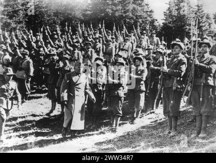 Benito Mussolini kommt vor Truppen alpiner Schützlinge und Milizen vorbei, die ihn mit Bajonetten in der Luft begrüssen. Juli 1940 Stockfoto