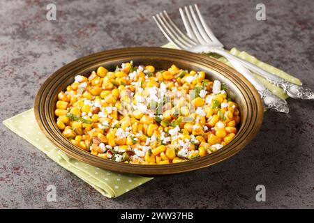 Hausgemachte mexikanische Street Corn Esquites mit Lime und Chili Nahaufnahme auf dem Teller auf dem Tisch. Horizontal Stockfoto