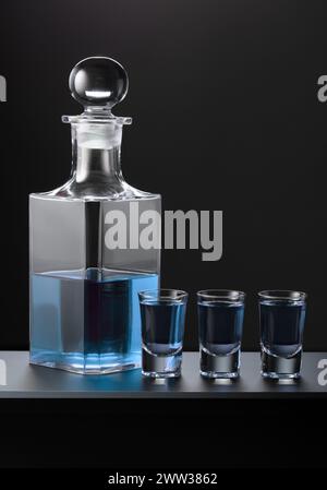 Alte Karaffe und Gläser mit blauem Gin auf schwarzem Hintergrund. Stockfoto