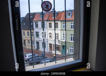 Wismar, Deutschland. März 2024. Nach dem Umbau in das Kittchen-Hostel können die Übernachtungsgäste durch ein versperrtes Hotelzimmerfenster im ehemaligen Jugendgefängnis über die Altstadt blicken. Ab dem Sommer bietet ein Hostel im Stadtzentrum eine besondere Art von Übernachtung. Das 2008 stillgelegte Gebäude wird derzeit mit rund 3,5 Millionen Euro renoviert. In 31 Zimmern sind rund 100 Betten geplant. Einige der Hotelzimmer sind ehemalige Gefängniszellen - die kleinste misst zweimal dreieinhalb Meter Guthaben: dpa/Alamy Live News Stockfoto