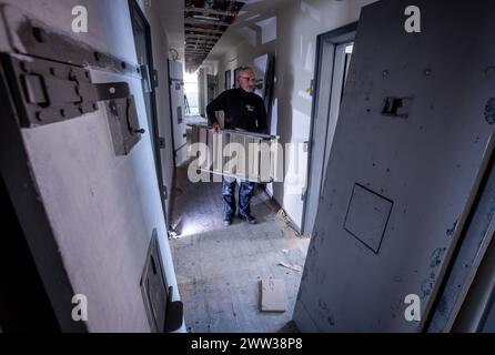 Wismar, Deutschland. März 2024. Handwerker arbeiten zwischen den ursprünglichen Gefängnistüren in einem Zellkorridor im ehemaligen Jugendgefängnis während des Umbaus zum Hostel „das Kittchen“. Ab dem Sommer bietet ein Hostel im Stadtzentrum eine besondere Art von Übernachtung. Das 2008 stillgelegte Werk wird derzeit zu Kosten von rund 3,5 Millionen Euro renoviert. In 31 Zimmern sind rund 100 Betten geplant. Einige der Hotelzimmer sind ehemalige Gefängniszellen - die kleinste misst zweimal dreieinhalb Meter. Mit einem Etagenbett Guthaben: dpa/Alamy Live News Stockfoto