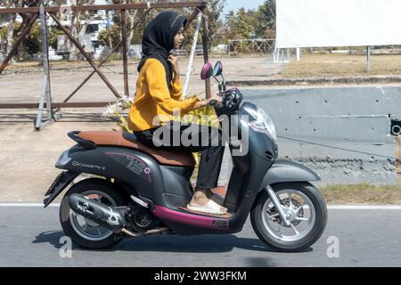 YALA, THAILAND, 1. März 2024, Junge Frau, die ein Motorrad in der Stadt fährt Stockfoto