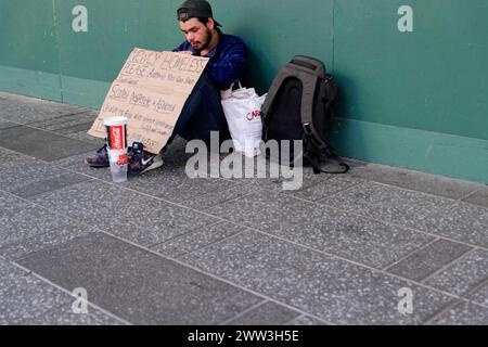 Ein Obdachloser sitzt auf dem Bürgersteig mit einem Schild, das um Hilfe bittet. Manhattan, New York City, New York, USA. Nordamerika Stockfoto