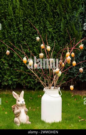 Ein Osterhase aus Porzelan mit einem Osterstrauß mit Ostereiern im Garten. Symbolfoto, Themenfoto *** Ein Porzellan-Osterhase mit Ostereierstrauß im Garten Symbolfoto, Themenfoto Foto:XB.xSchubertx/xFuturexImagex ostern 4301 Stockfoto