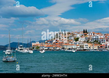 Blick auf eine idyllische Küstenstadt mit weißen Häusern und Segelbooten auf klarem blauem Wasser, Blick von Galatas, Argolis, nach Poros, Poros Insel, Saronisch Stockfoto