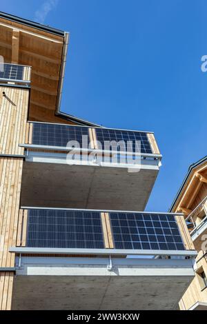 Sonnenkollektoren auf den Balkonen eines Holzhauses Stockfoto