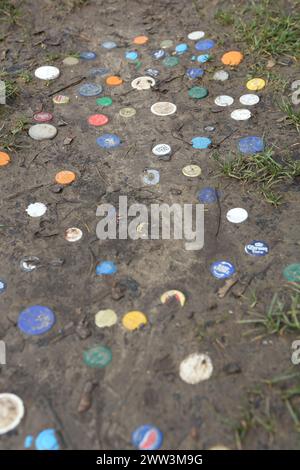 In Schlamm gepresste Plastikflaschendeckel und Metallflaschendeckel Stockfoto