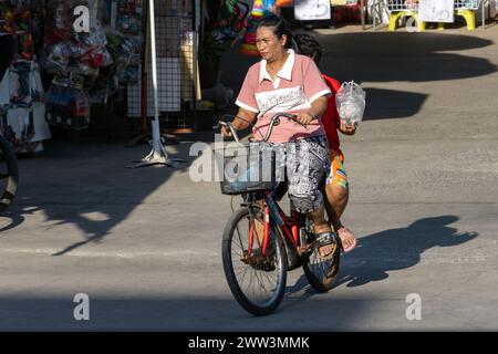 SAMUT PRAKAN, THAILAND, 07. Dezember 2023, Eine Frau fährt einen Jungen auf einem Fahrrad Stockfoto