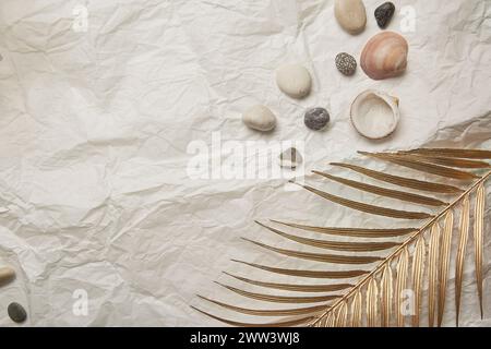 Sammlung von Muscheln und Steinen auf einem zerknitterten Papierhintergrund. Kopierbereich. Stockfoto