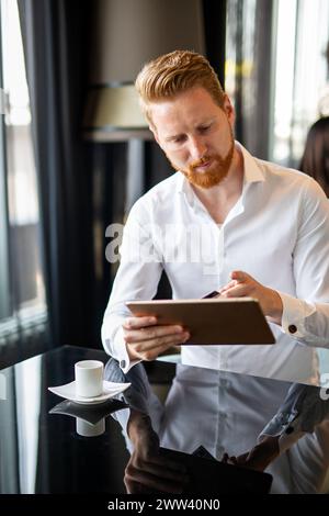 Glücklicher erfolgreicher Geschäftsmann beim Online-Shopping oder zufriedener Unternehmer bei Online-Zahlungen Stockfoto