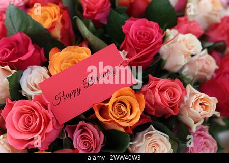 Blumenstrauß mit schönen Rosen mit Happy Birthday Karte, Nahaufnahme Stockfoto