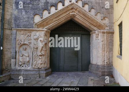 Die Basilika di San Fedele in Como, Italien. Das Nordosttor wird auf beiden Seiten von romanischen Basreliefschnitzereien flankiert. Stockfoto