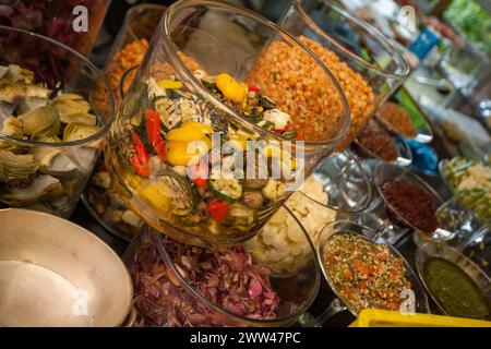 Dieses Bild zeigt ein üppiges Buffet mit einer Auswahl an frischen, farbenfrohen Salaten in großen Glasschalen, die eine Vielzahl von Texturen und Zutaten zeigen und die Gäste einladen, sich mit gesunden Speisen verwöhnen zu lassen. Gourmet-Buffet mit einer Auswahl an frischen Salaten. Hochwertige Fotos Stockfoto