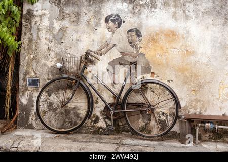 Kleine Kinder auf einem Fahrrad Wandgemälde in der Armenischen Straße, George Town, Penang vom litauischen Künstler Ernest Zacharevic. Stockfoto