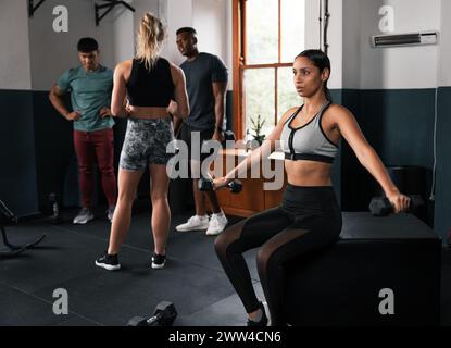 Frau auf der Turnbank, die Hantel hält und sich auf die Beinmuskelübung konzentriert Stockfoto