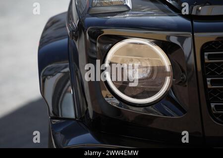 Vorderteil eines modernen schwarzen SUV mit Scheinwerfer und Rad. Fahrzeugdesign. Stockfoto