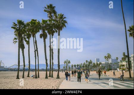 10. März 2024, Los Angeles, USA. Venedig Strand an einem hellen, sonnigen Tag. Menschenmassen Touristen Wanderweg entlang der Fußgängerzone des Broadwalk. Radfahrer fahren auf der Fahrradstraße. Wunderschöner Blick aufs Meer Stockfoto