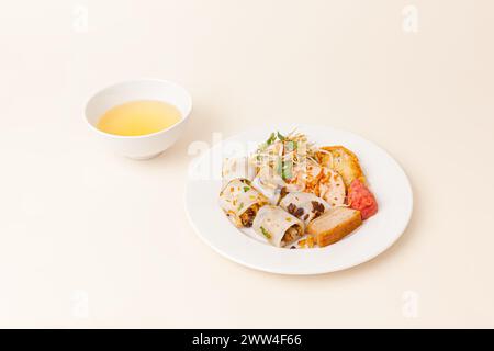 Banh Cuon, vietnamesische gedämpfte Reisbrötchen Pfannkuchen mit herzhafter Mischung aus gemahlenem Schweinefleisch, vietnamesisches Essen isoliert auf weißem Hintergrund, perspektivische Sicht Stockfoto