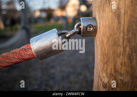 Ein Nahaufnahme eines Seils, das mit Metall an einem Holzpfosten befestigt ist Stockfoto