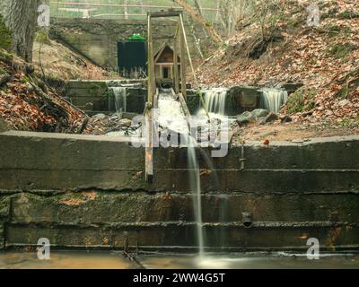 Inmitten der üppigen Schönheit von Kandava, Lettland, stürzt dieser kleine Wasserfall sanft und flüstert Melodien der Ruhe, die alle einladen, die Ruhe zu genießen Stockfoto